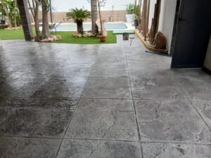 Hormigón impreso gris junto a jardín y piscina